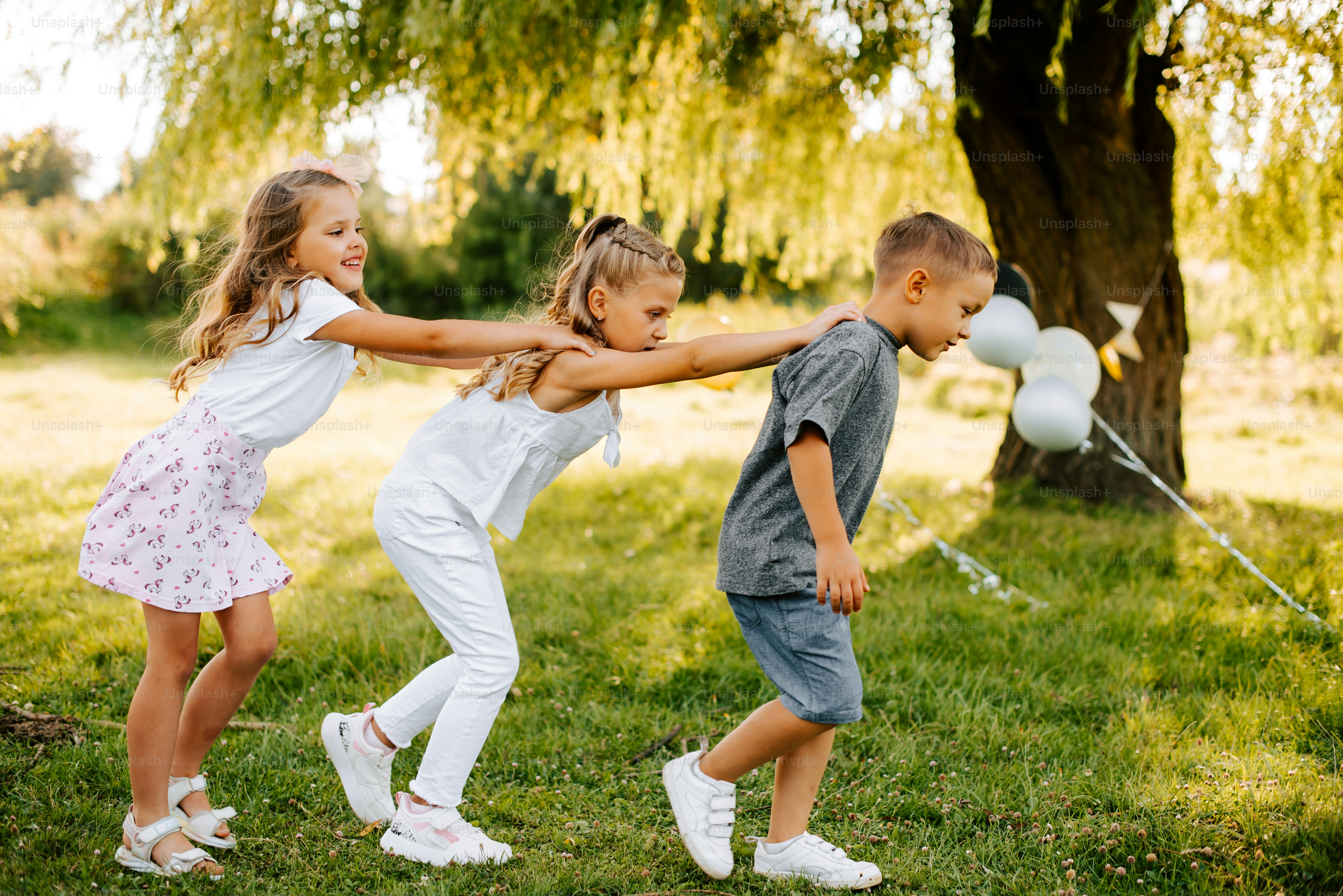 Eine Gruppe kleiner Kinder, die mit einem Drachen spielen