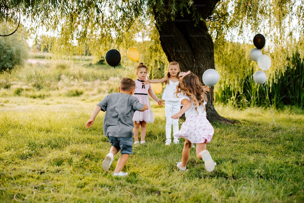 a group of children playing with balloons in a field