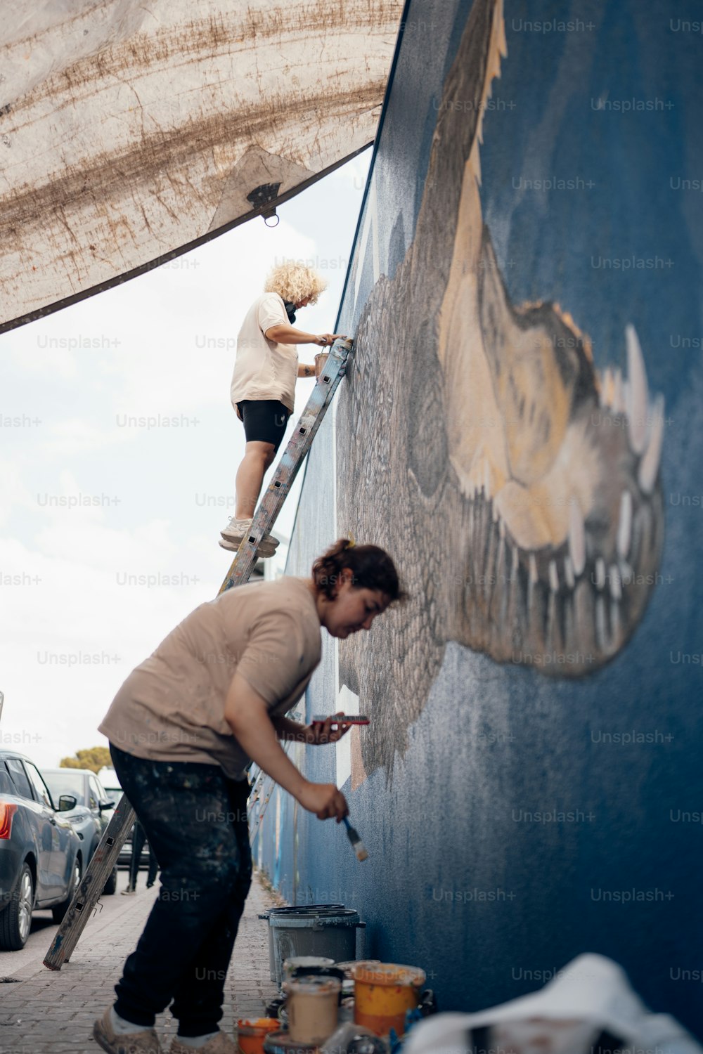Un uomo che dipinge un murale sul lato di un edificio