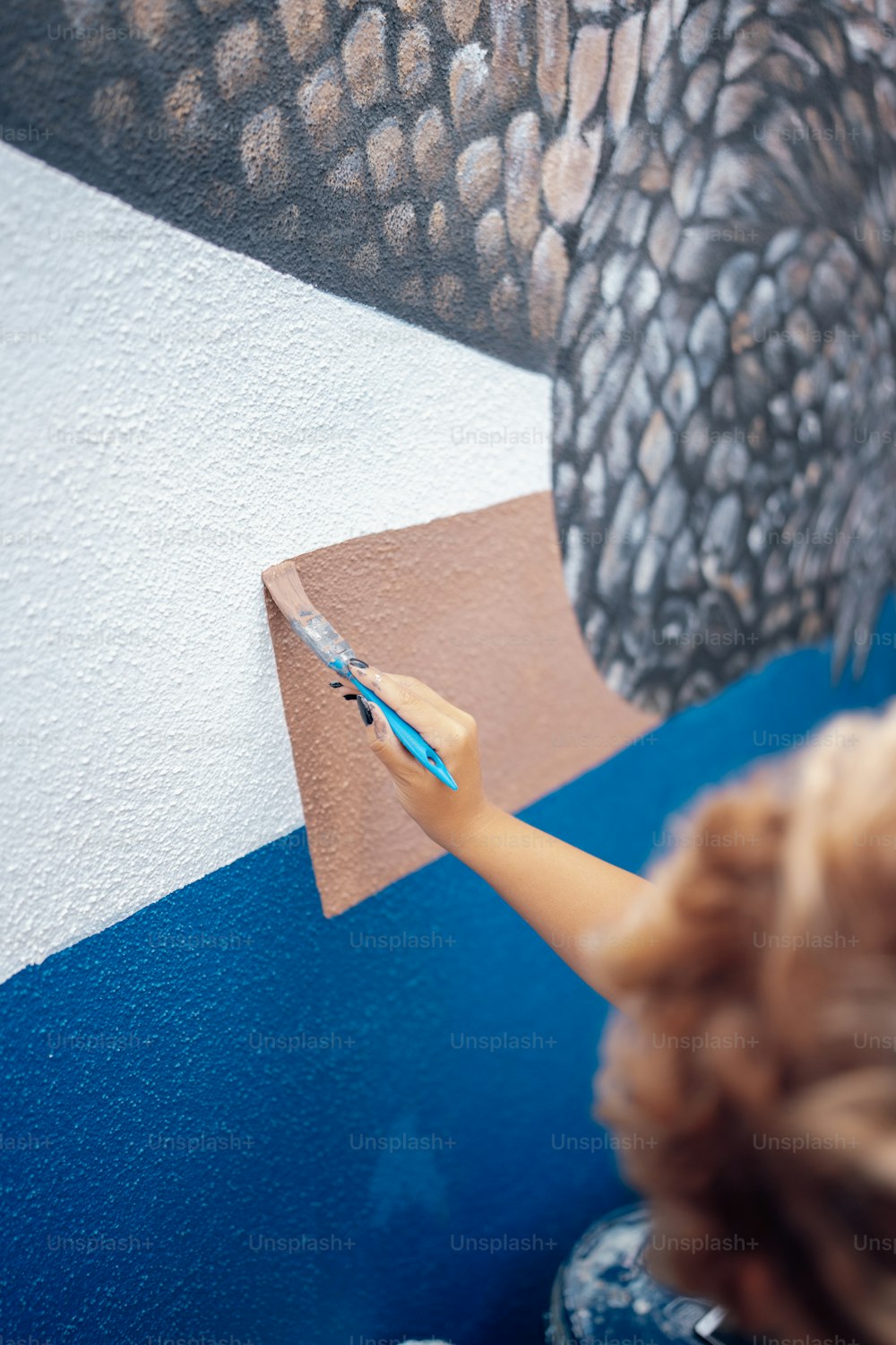 a little boy painting a picture of an elephant on a wall