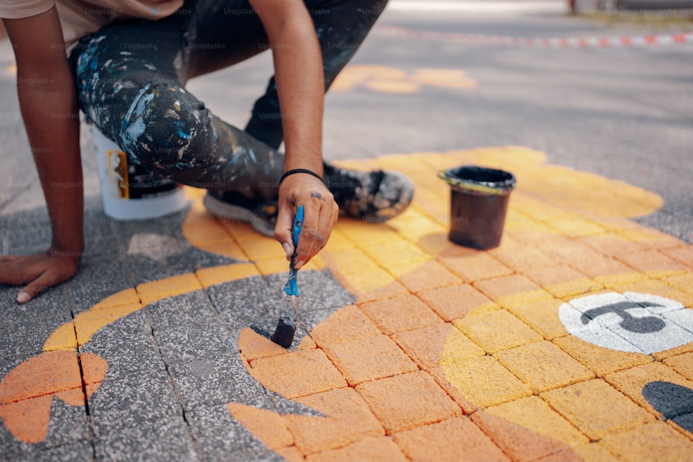 Un homme peint un trottoir avec un pinceau