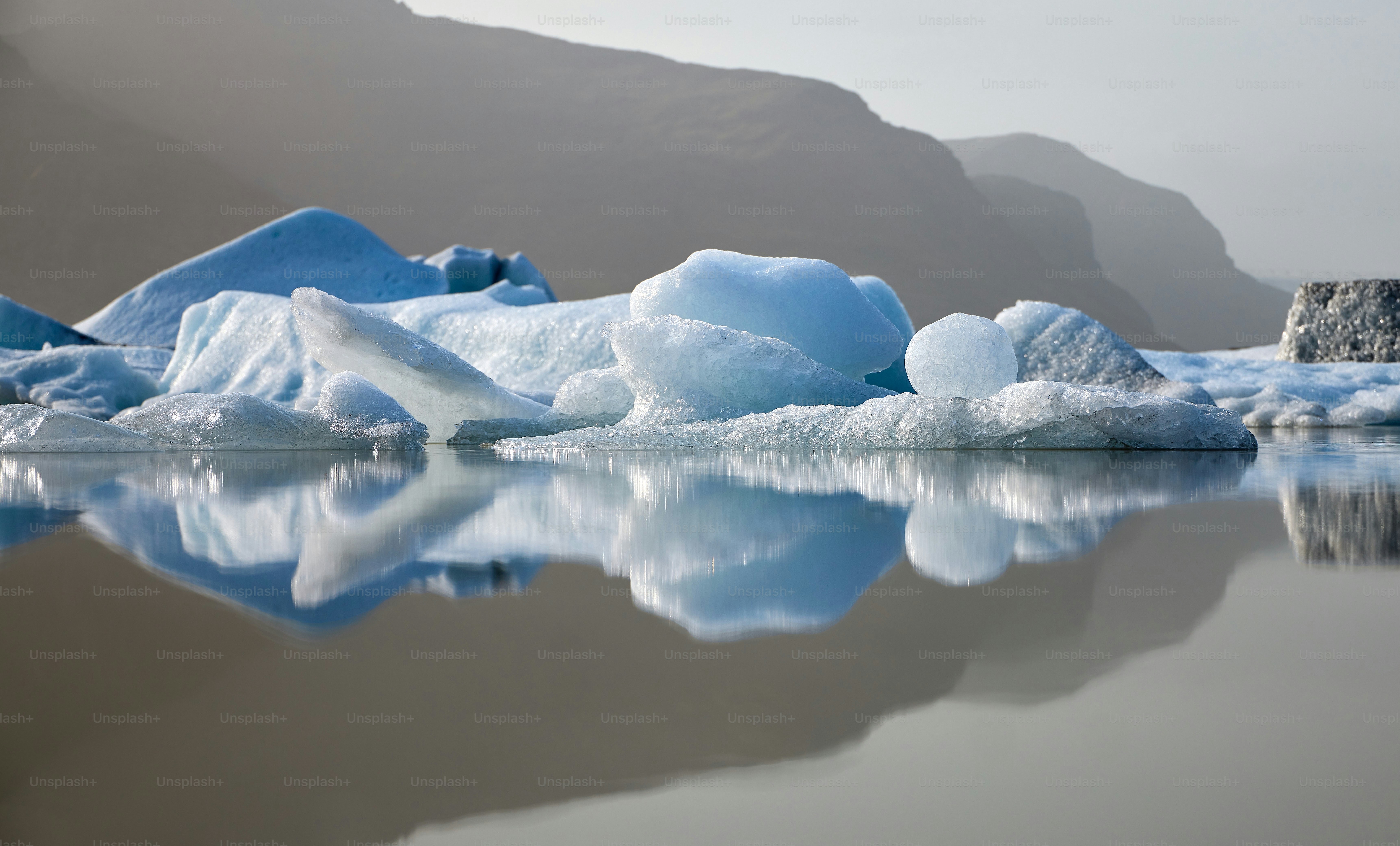 a group of icebergs floating on top of a lake