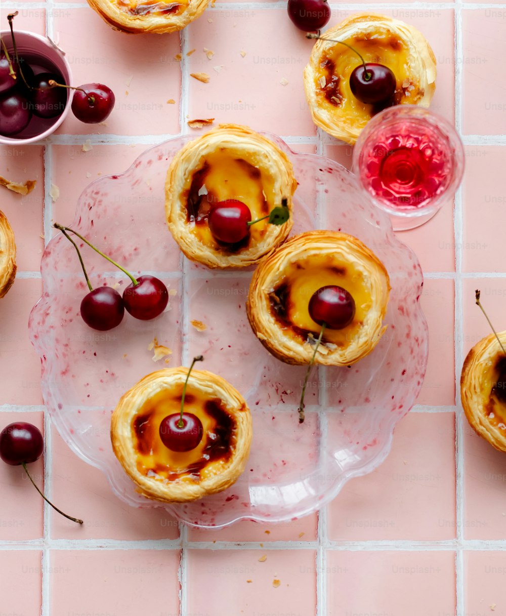 a plate of pastries with cherries on them