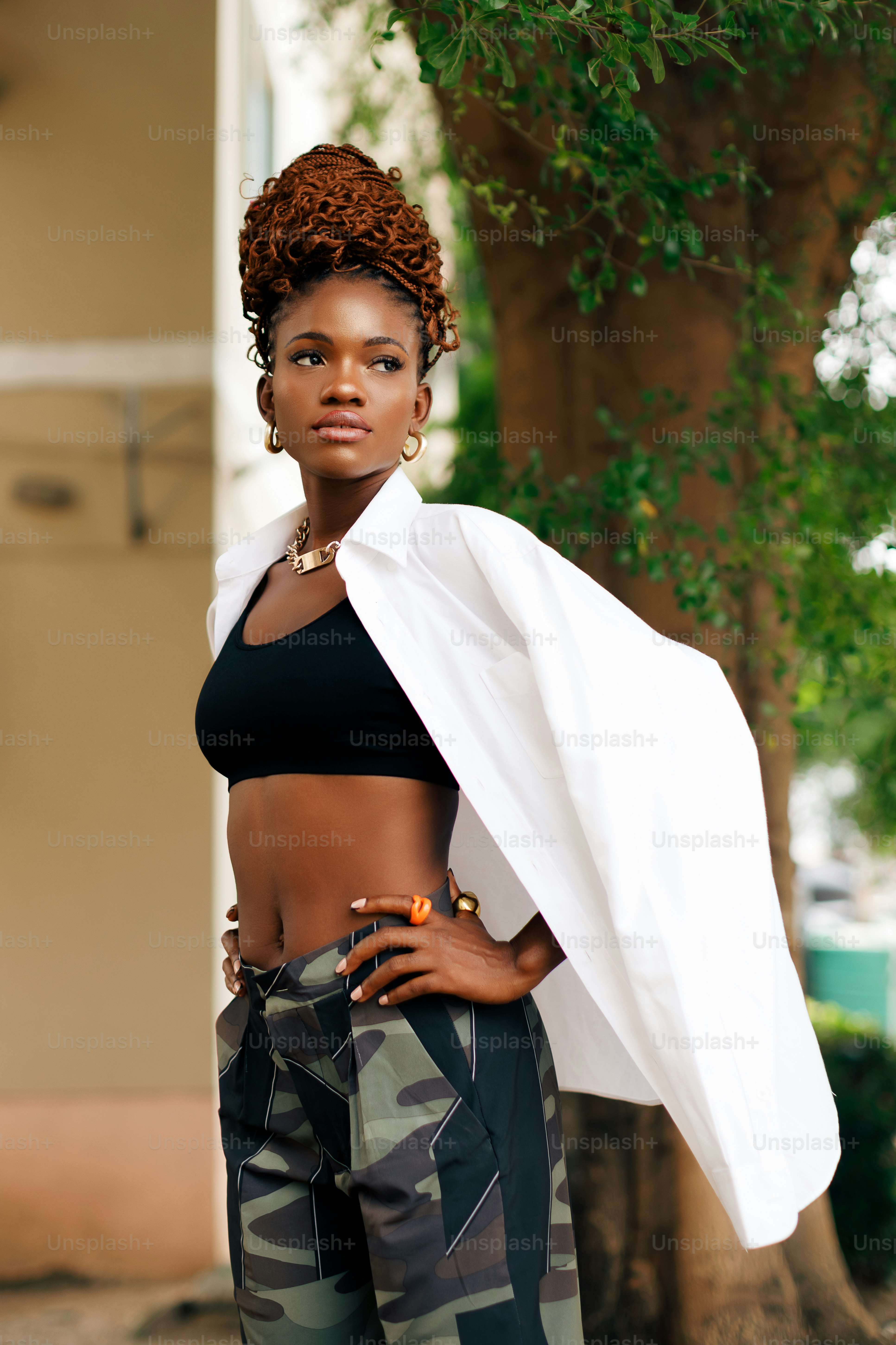 a woman in camouflage pants and a white jacket
