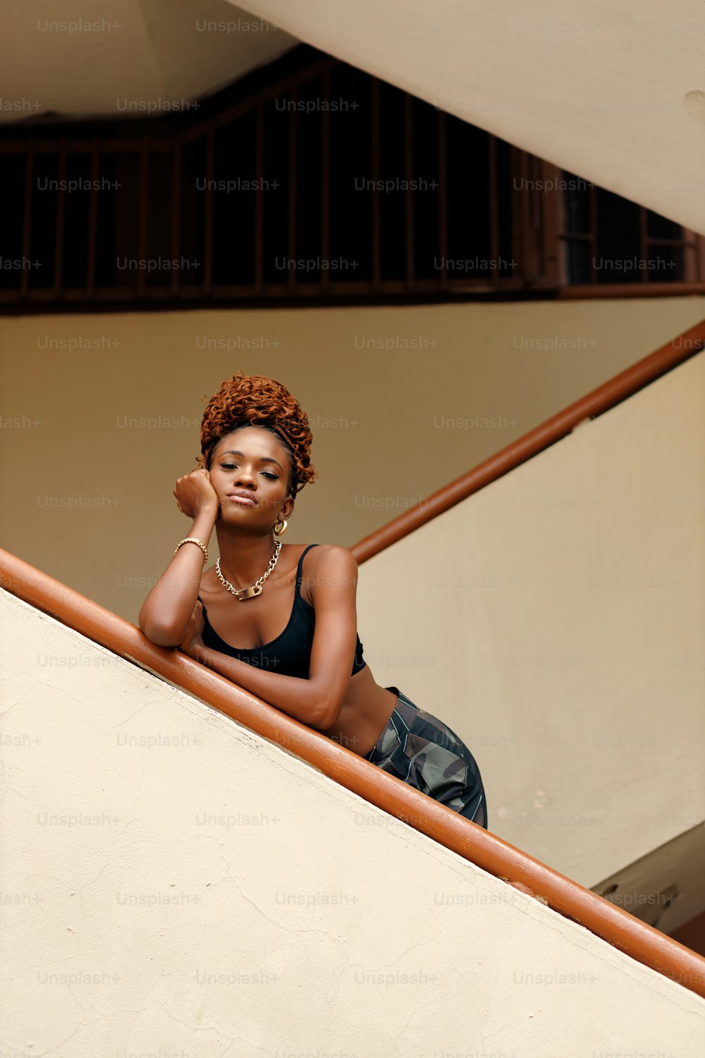 a woman in a black bikini top sitting on a stair case