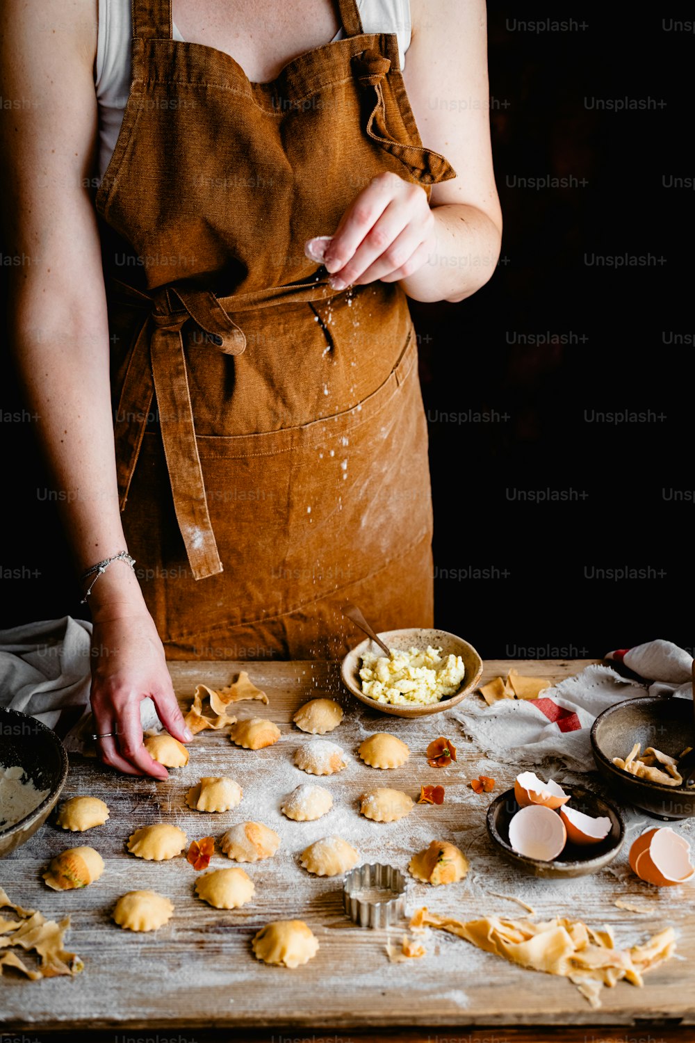a woman in an apron is making cookies
