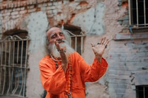 a man in an orange outfit holding his hands up