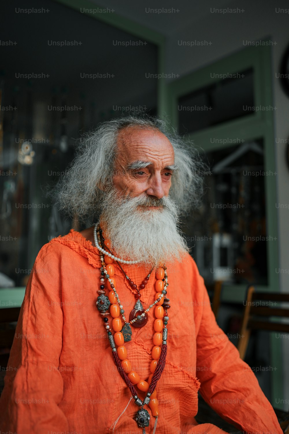 an old man with a long beard wearing a necklace