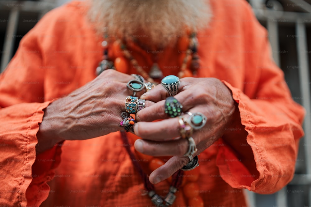 a man with a long beard wearing rings on his fingers