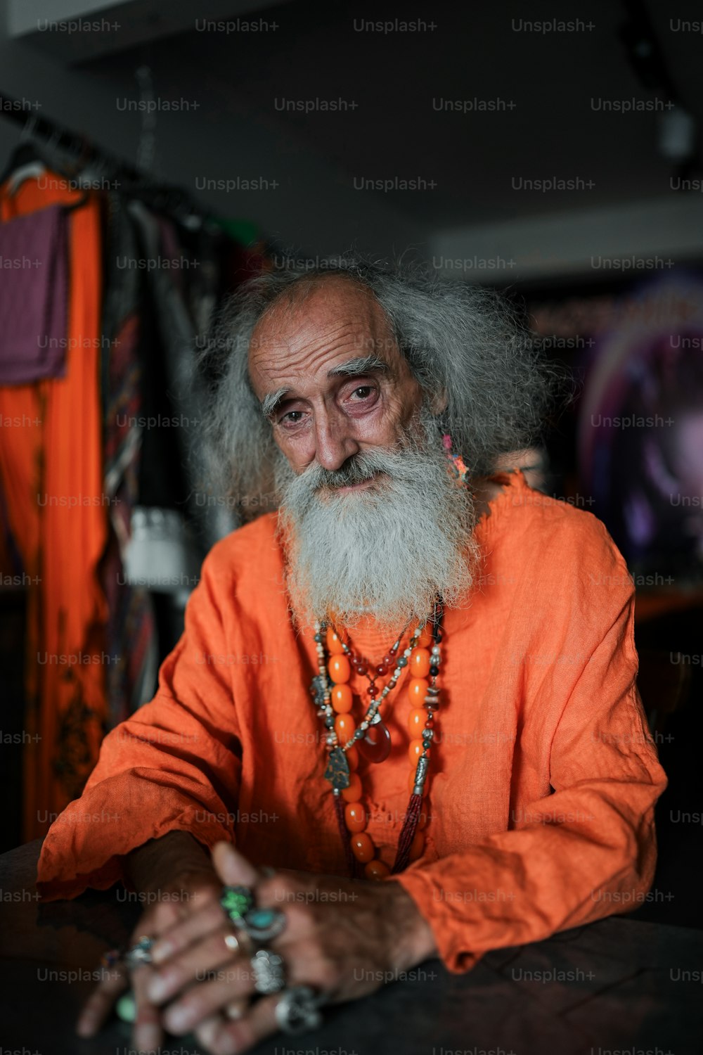 um homem com uma longa barba vestindo uma roupa laranja