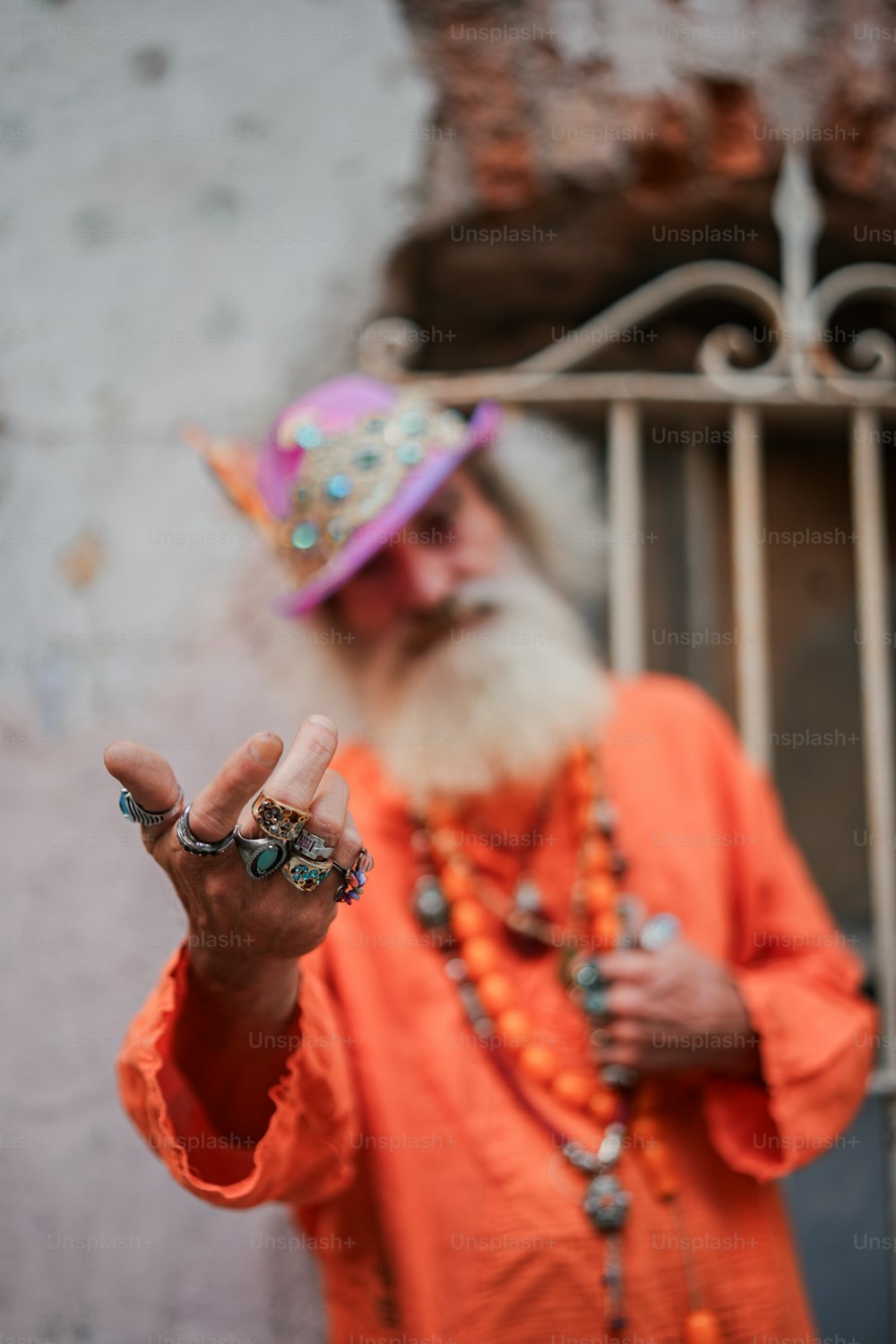 a man with a long white beard wearing an orange shirt