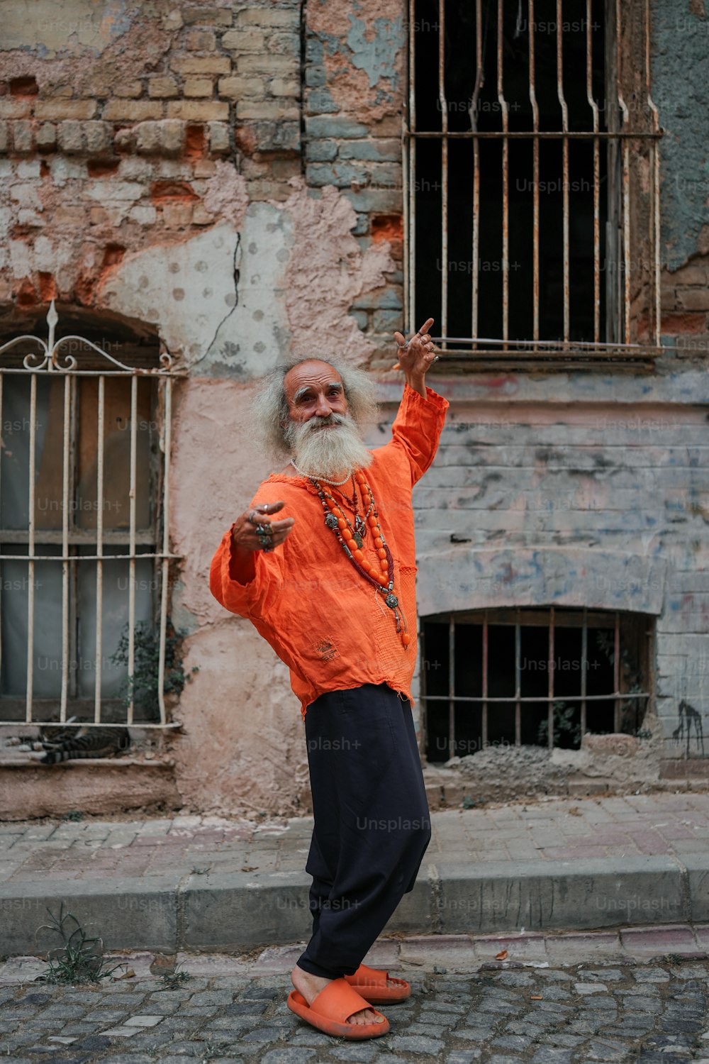 Un uomo con una lunga barba bianca e una camicia arancione