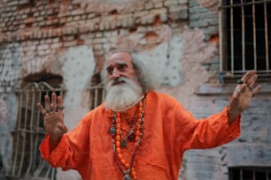 a man with a long white beard wearing an orange shirt