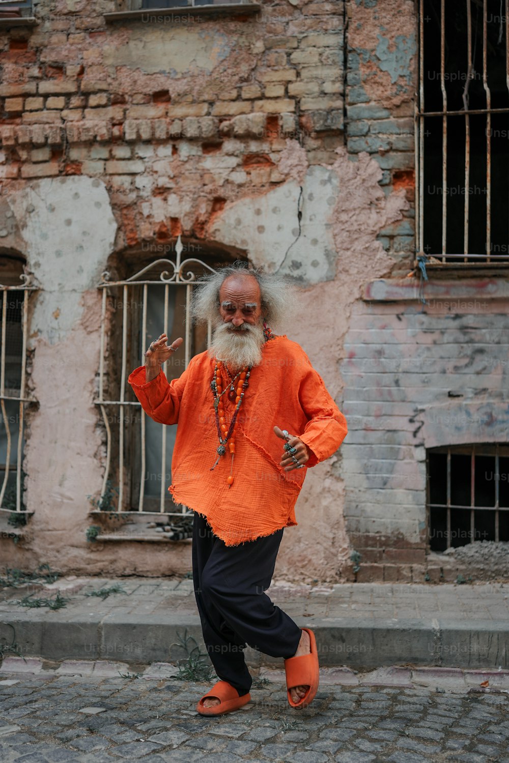 a man in an orange shirt is walking down the street