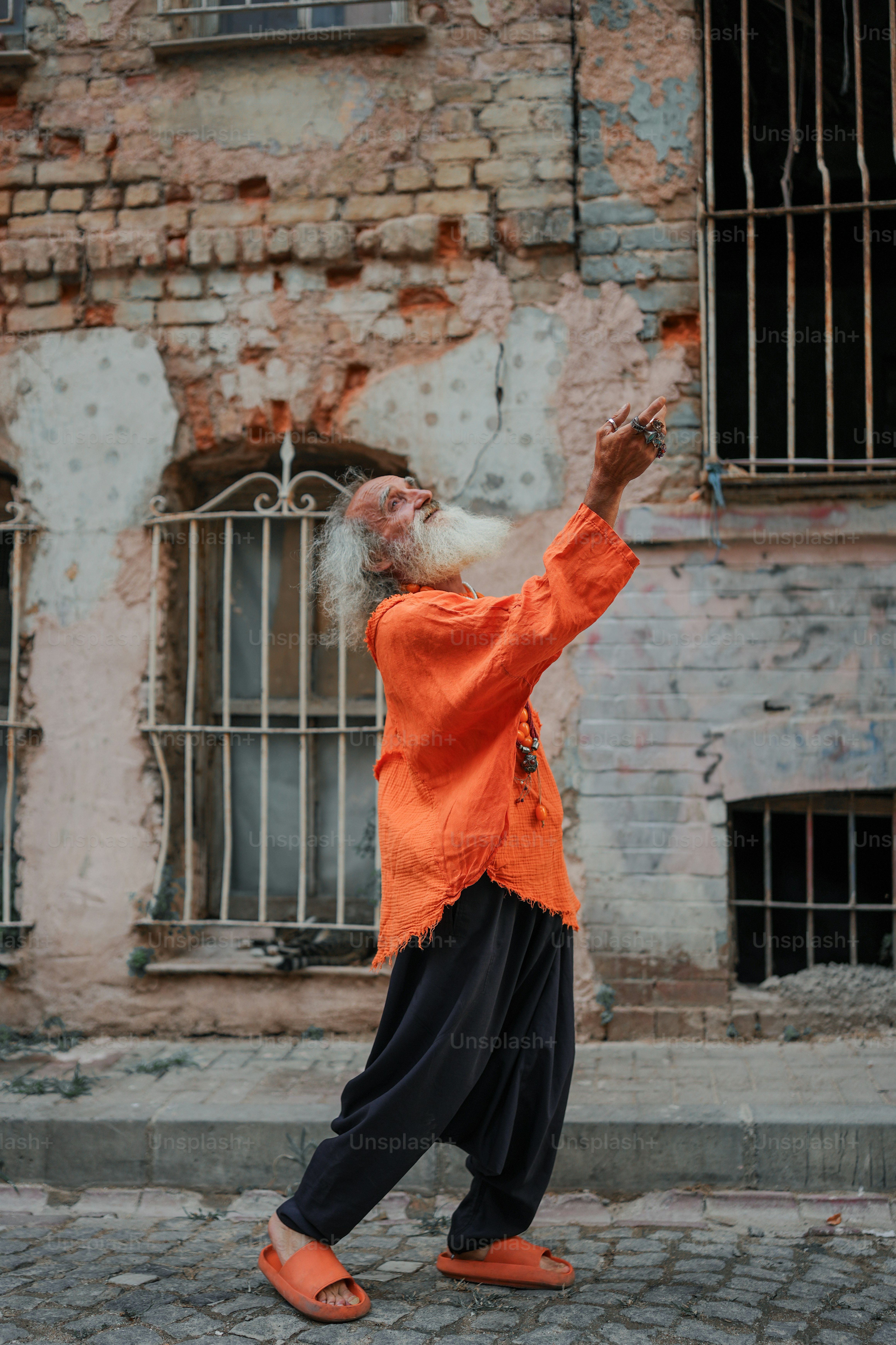 a man in an orange shirt and black pants is throwing a frisbee