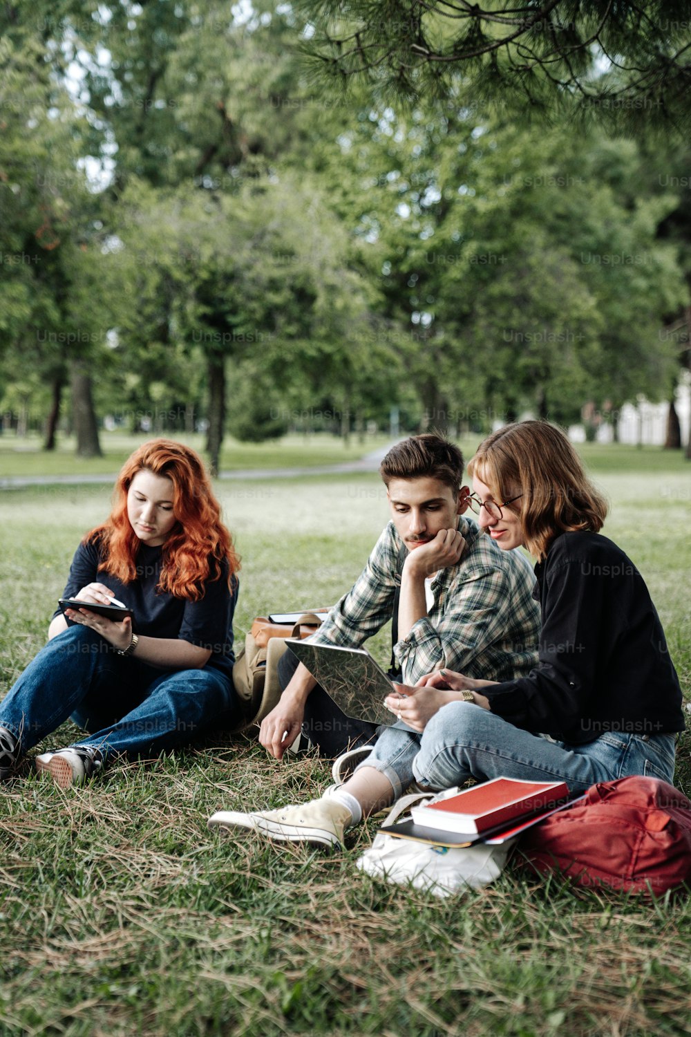 a group of young people sitting on the grass