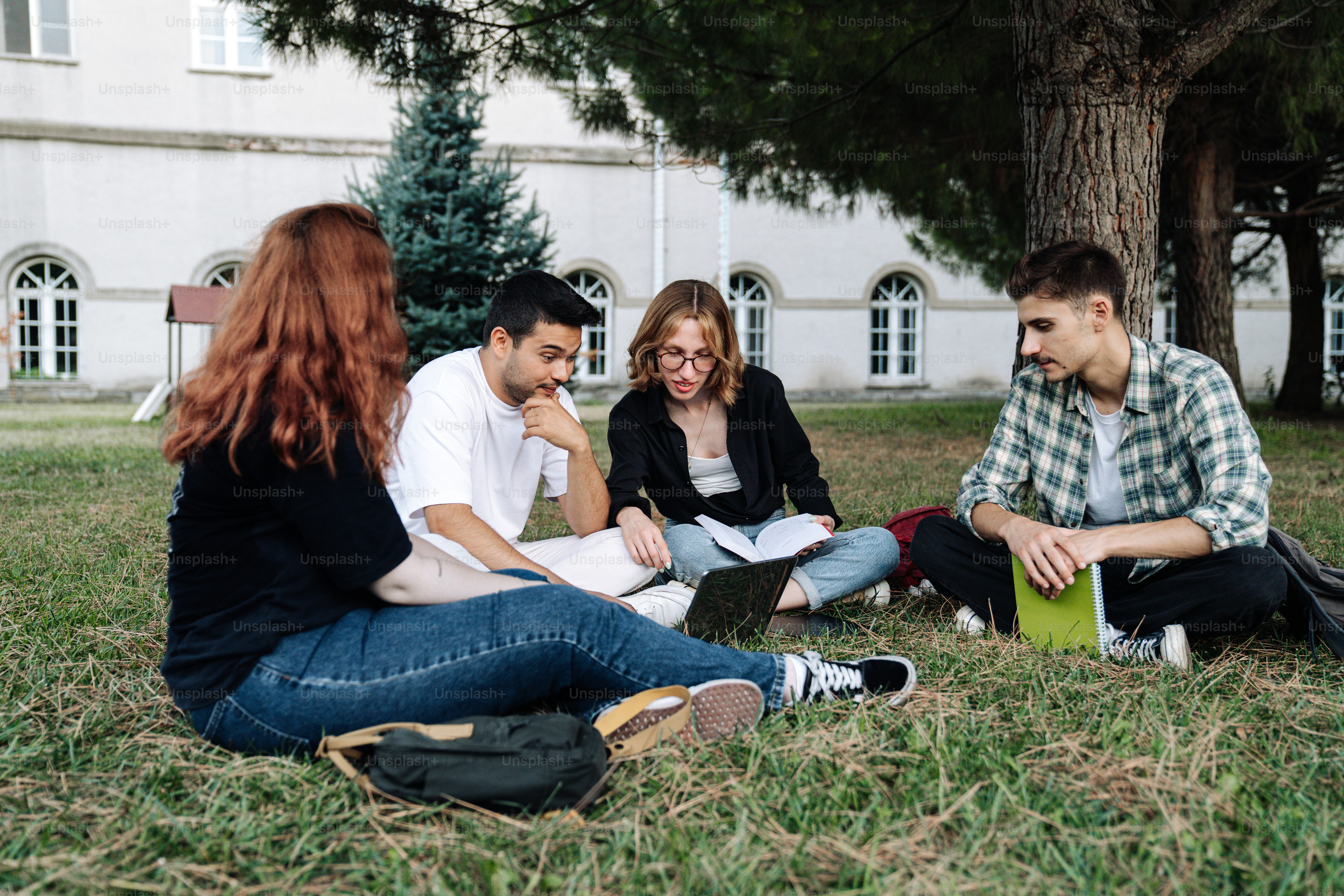 a group of young people sitting on the grass