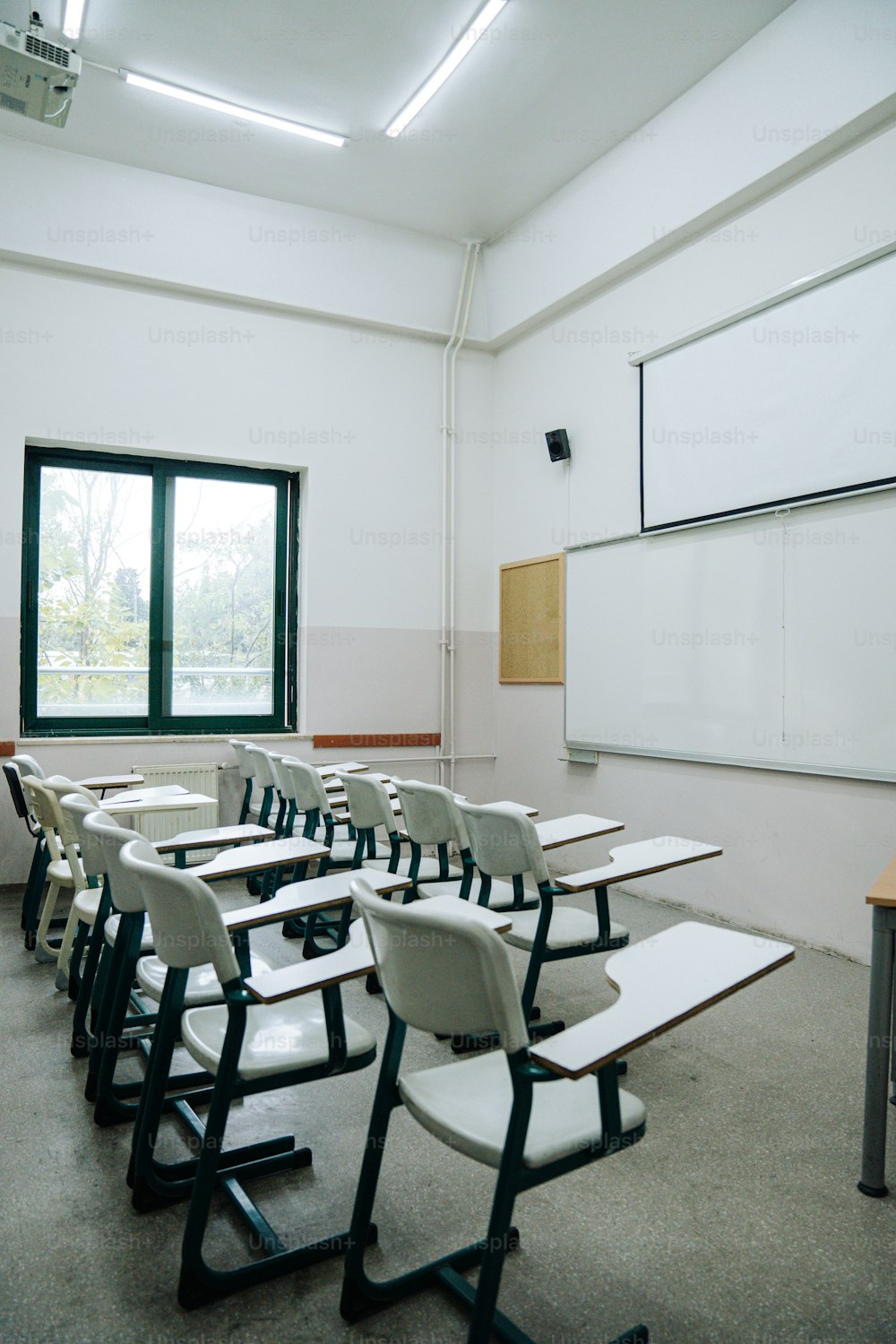 une salle de classe avec des chaises blanches et un tableau blanc