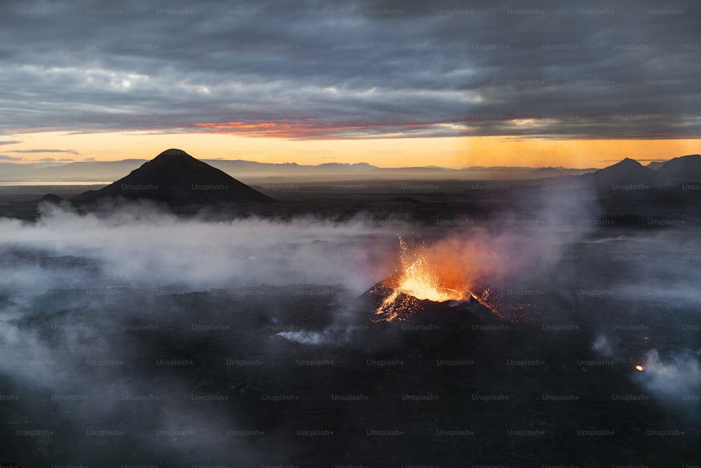 Un vulcano che vomita lava al tramonto