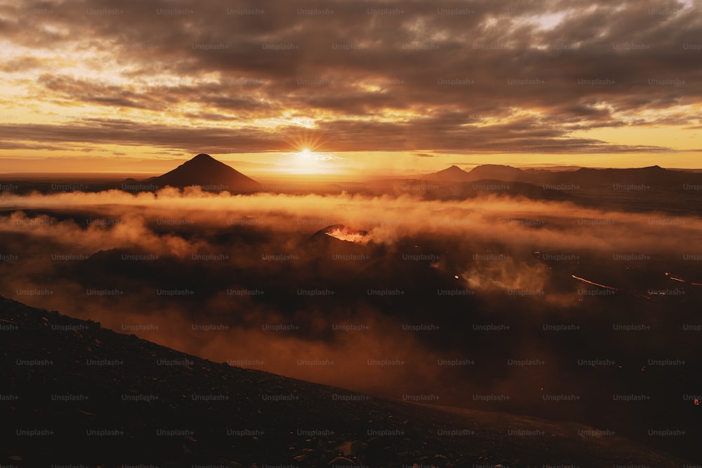 the sun is setting over a mountain range