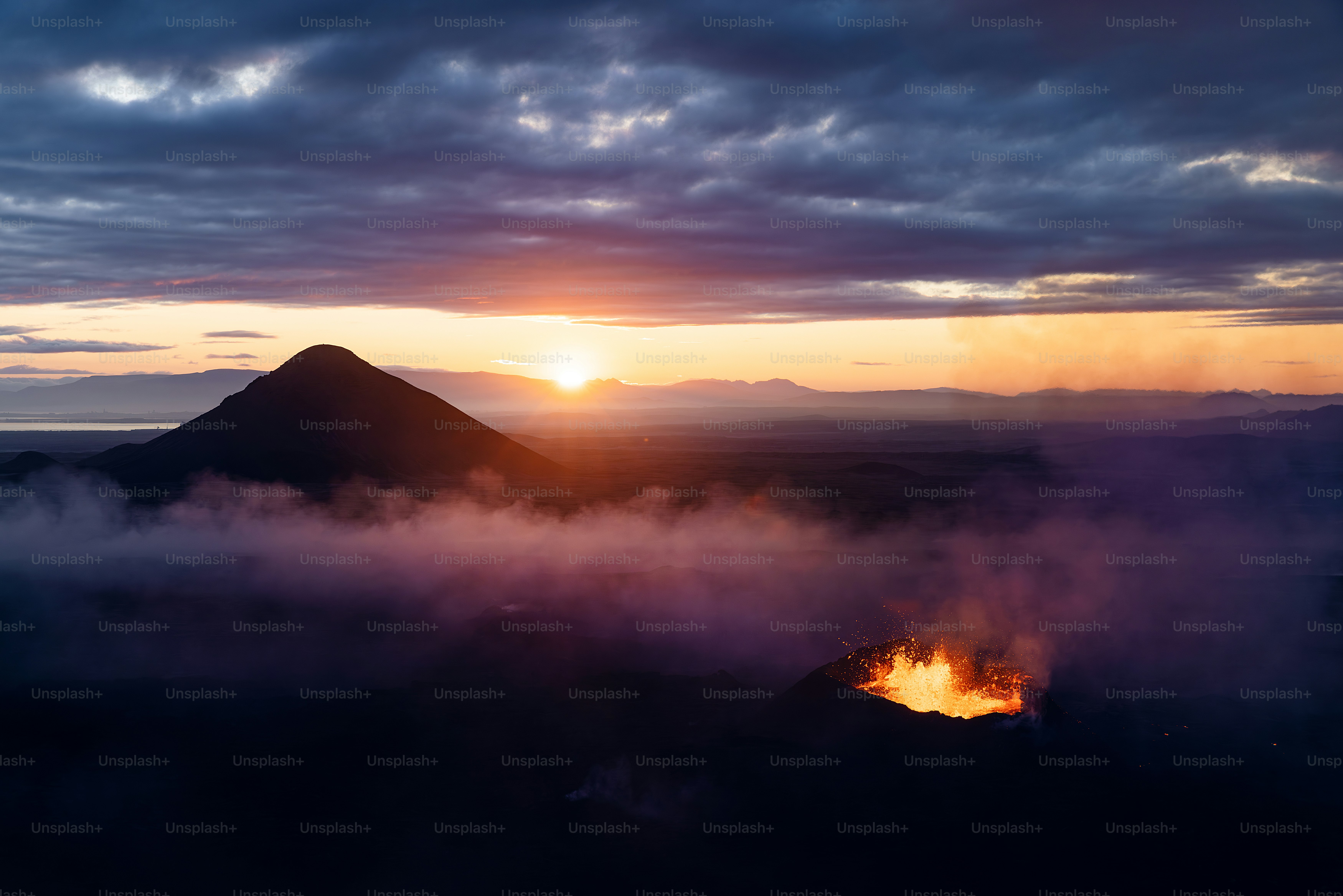 Le soleil se couche sur une montagne avec des nuages