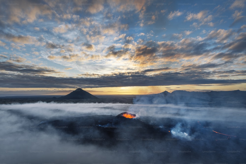 Il sole sta tramontando su una montagna coperta di nuvole