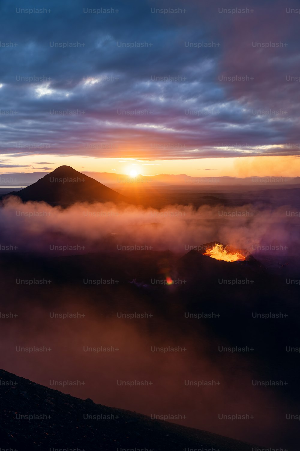 the sun is setting over the clouds and mountains