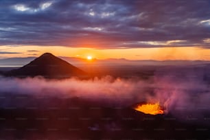 the sun is setting over a mountain range