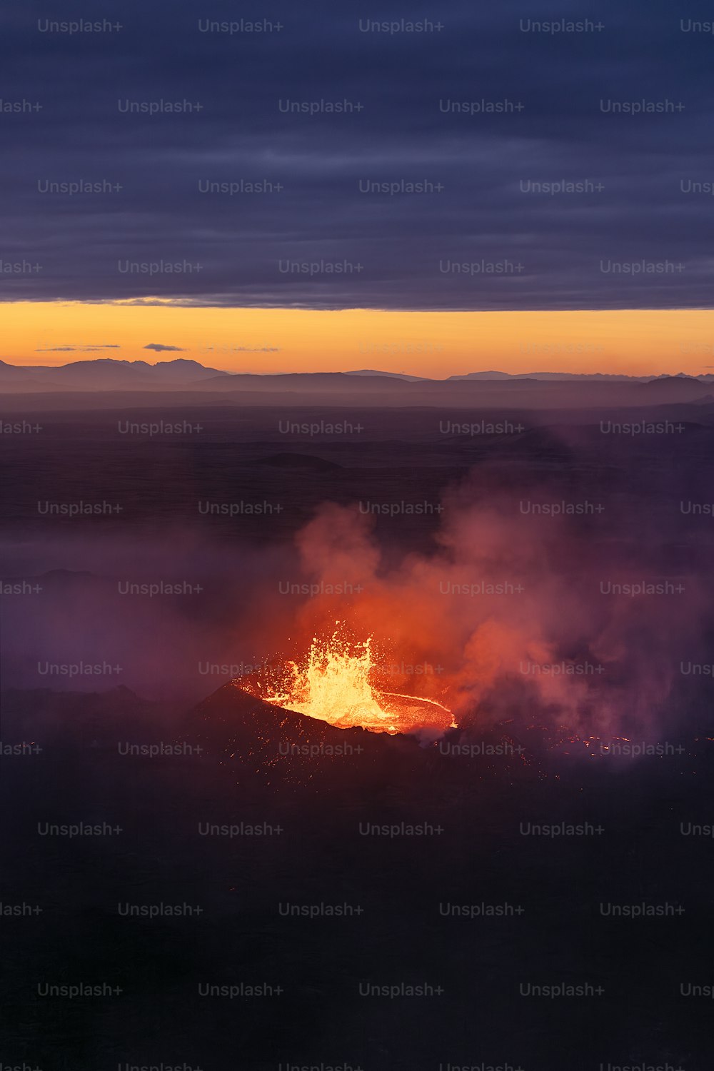 Un volcan fait éruption de lave au coucher du soleil