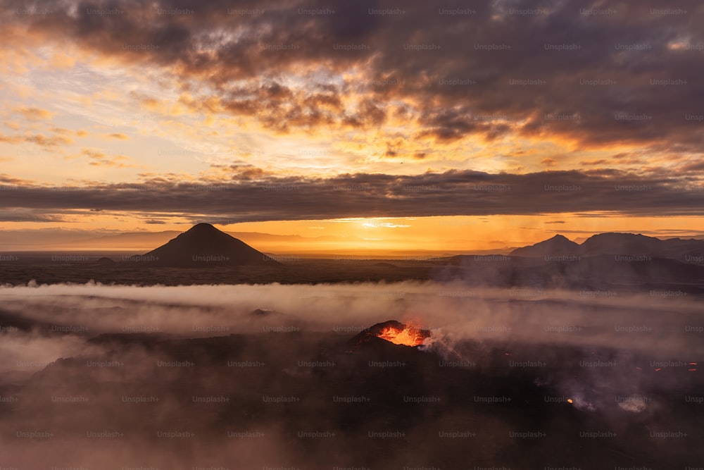 the sun is setting over a mountain range