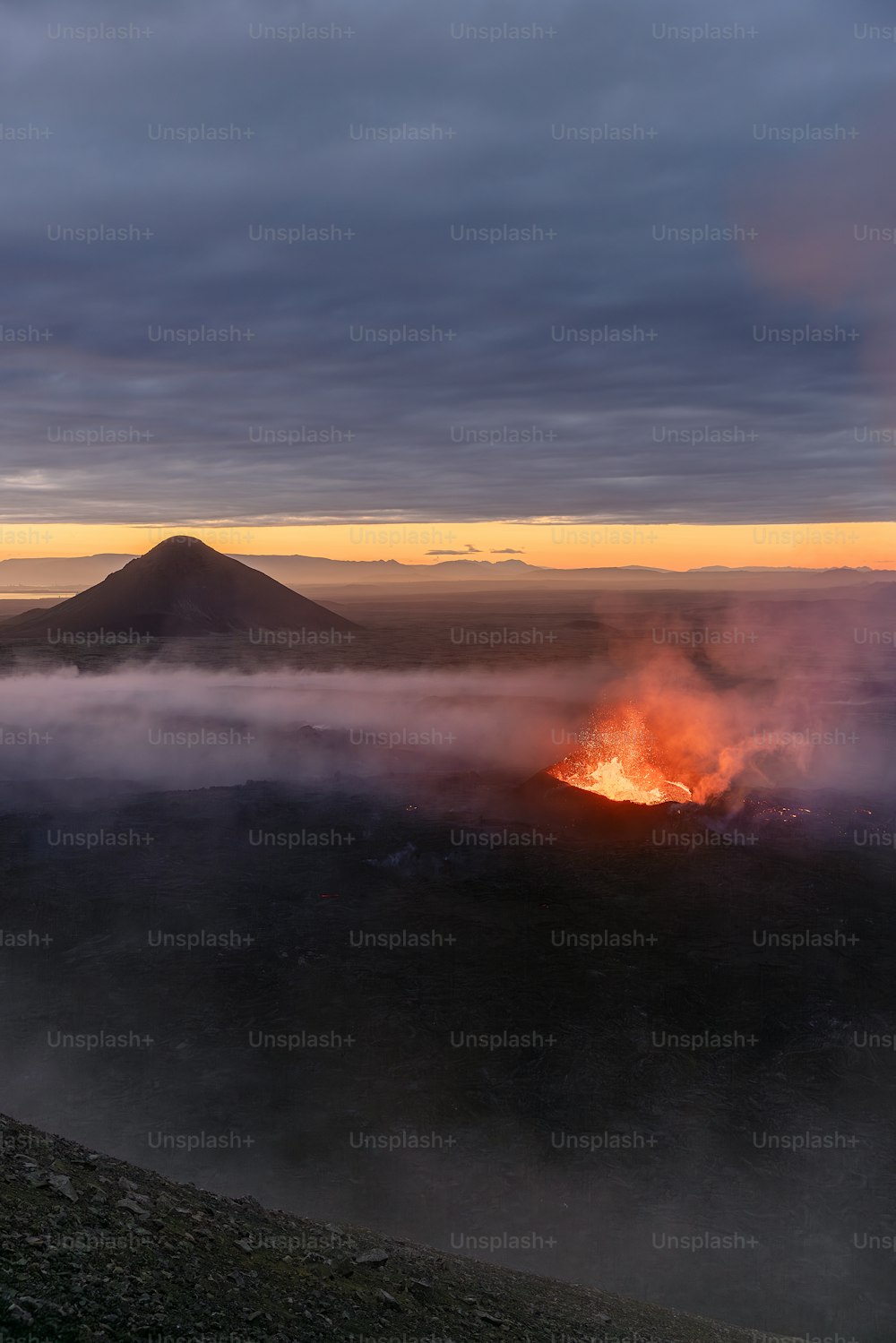 Un vulcano che vomita lava in lontananza