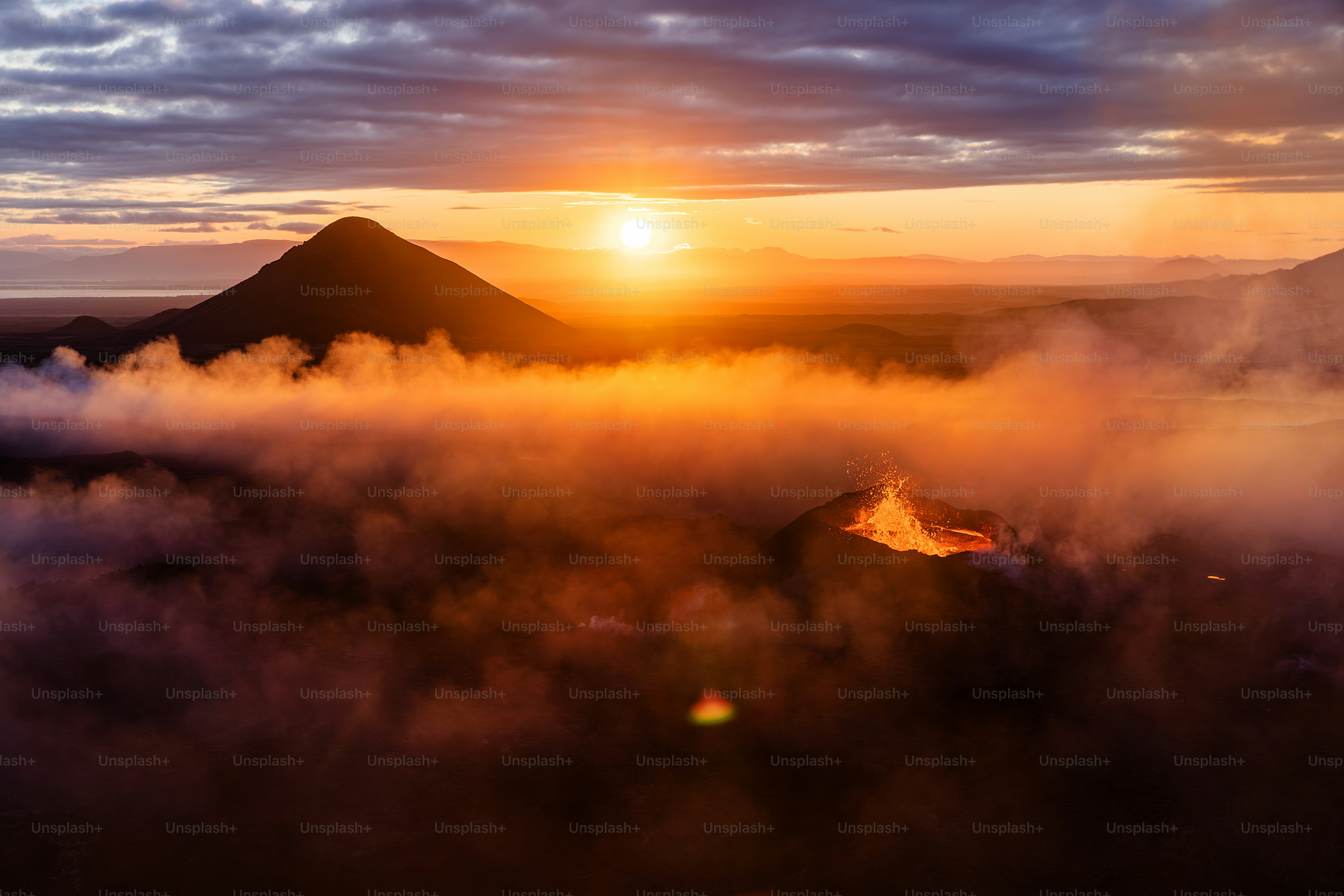 the sun is setting over a mountain range