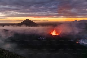 谷の真ん中で溶岩を噴き出す火山