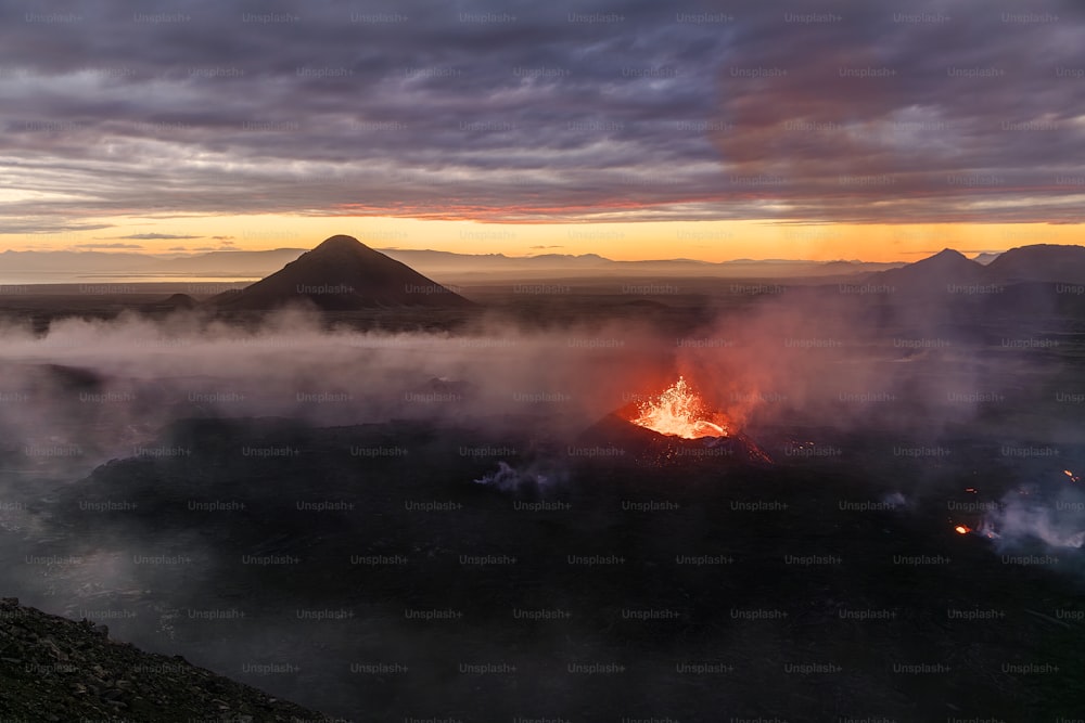 um vulcão expelindo lava no meio de um vale