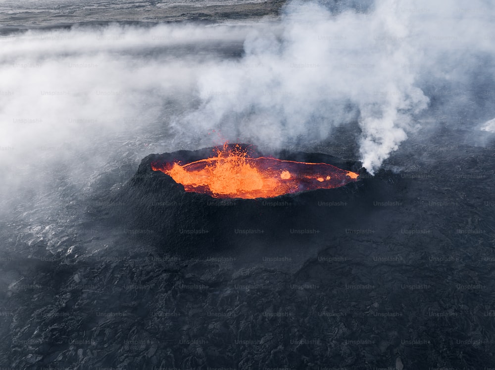 uma vista aérea de um lago de lava com vapor subindo dele