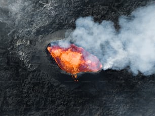 an aerial view of a volcano with smoke coming out of it
