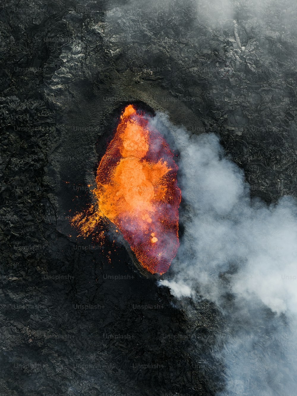 an aerial view of a volcano with lava and smoke