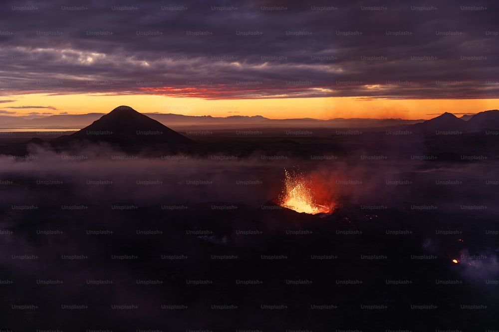 um vulcão expelindo lava ao pôr do sol