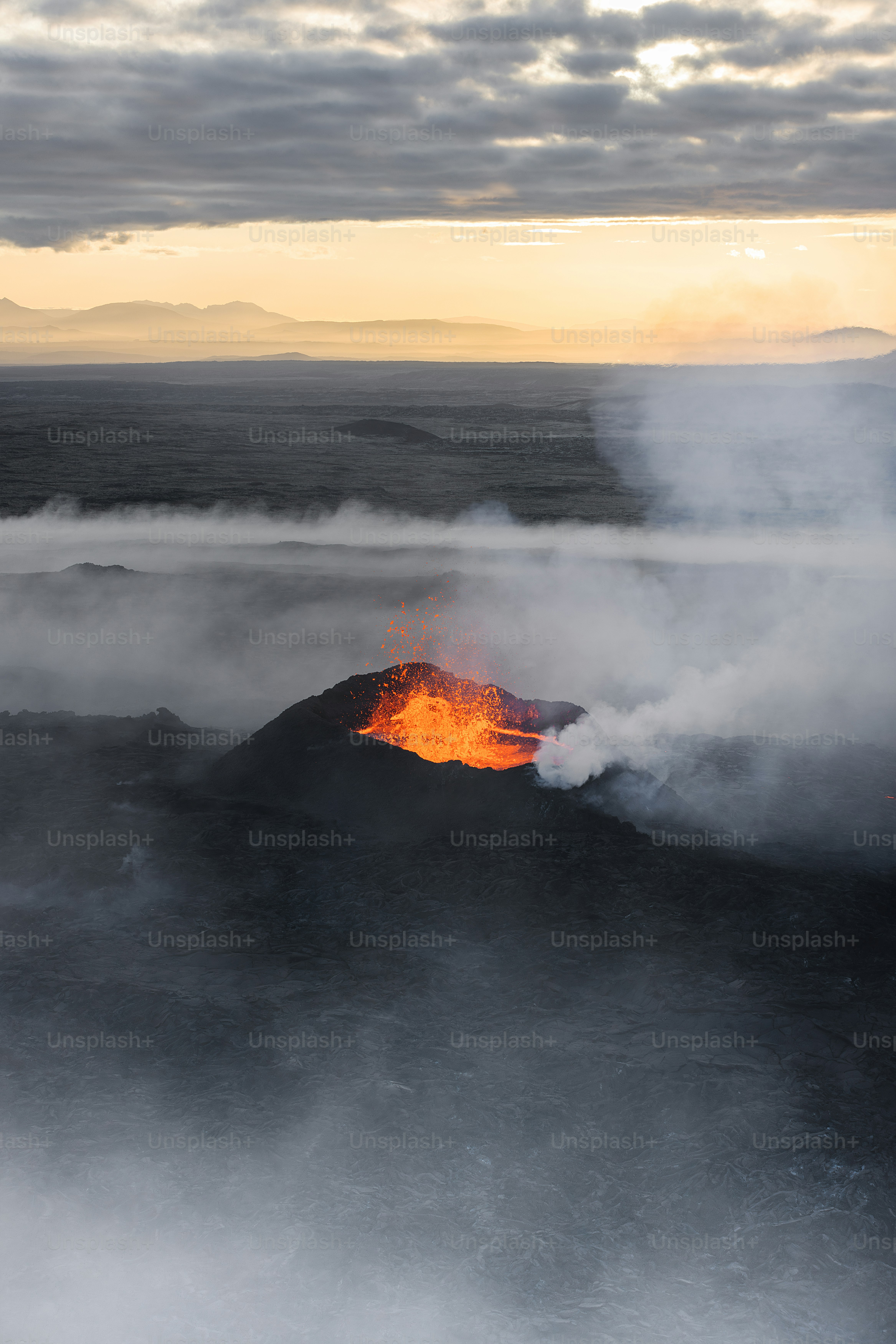 A volcano spewing out lava into the ocean photo – Smoke Image on Unsplash