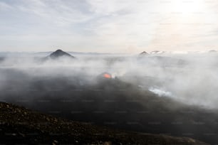 Ein nebliger Berg mit einem roten Hydranten im Vordergrund