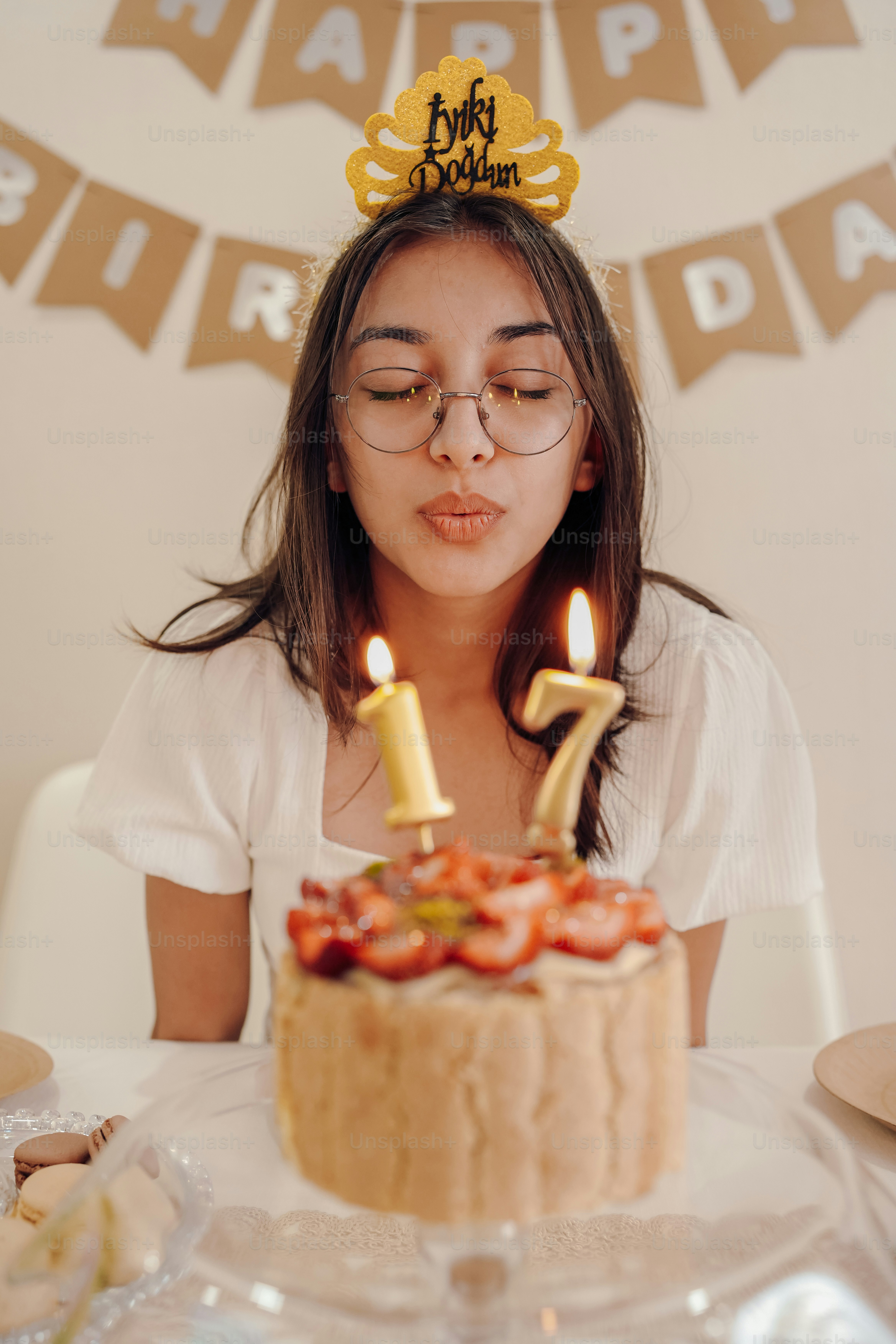 a woman blowing out candles on a cake