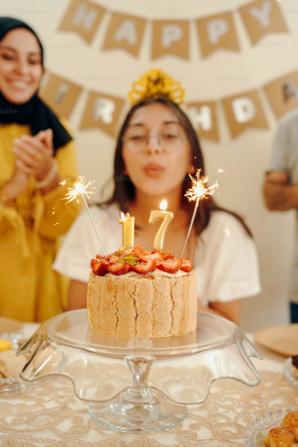 a young girl blowing out candles on a birthday cake