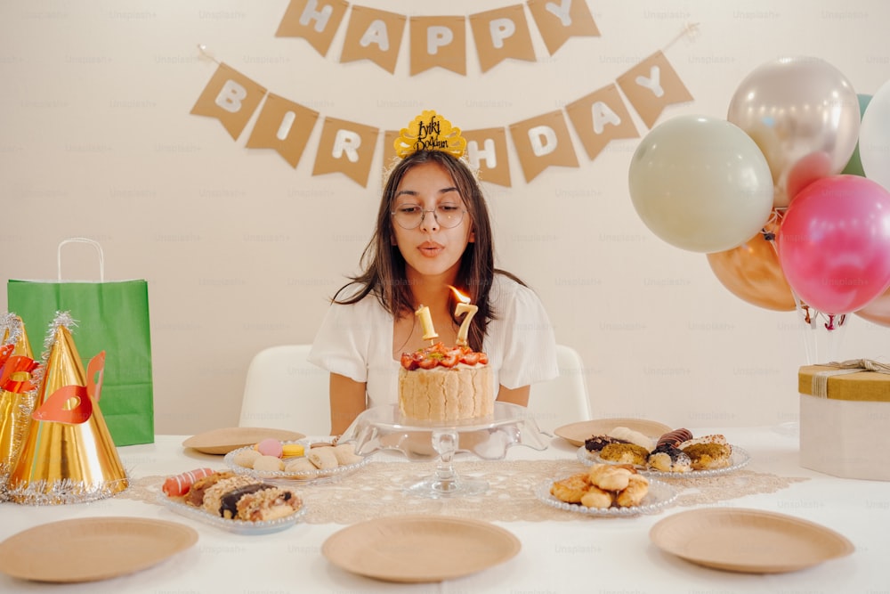 a woman sitting at a table with a birthday cake