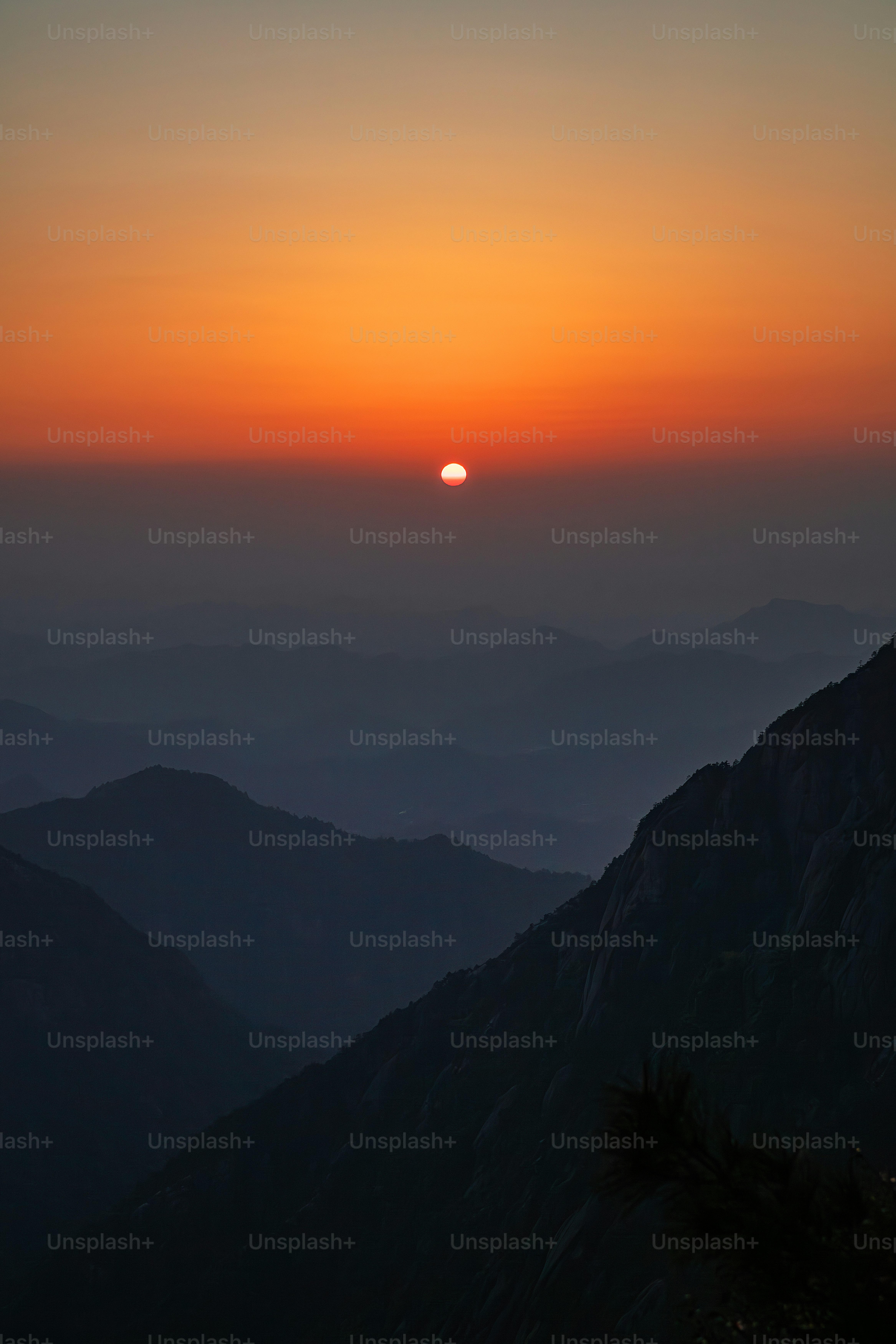 the sun is setting over a mountain range