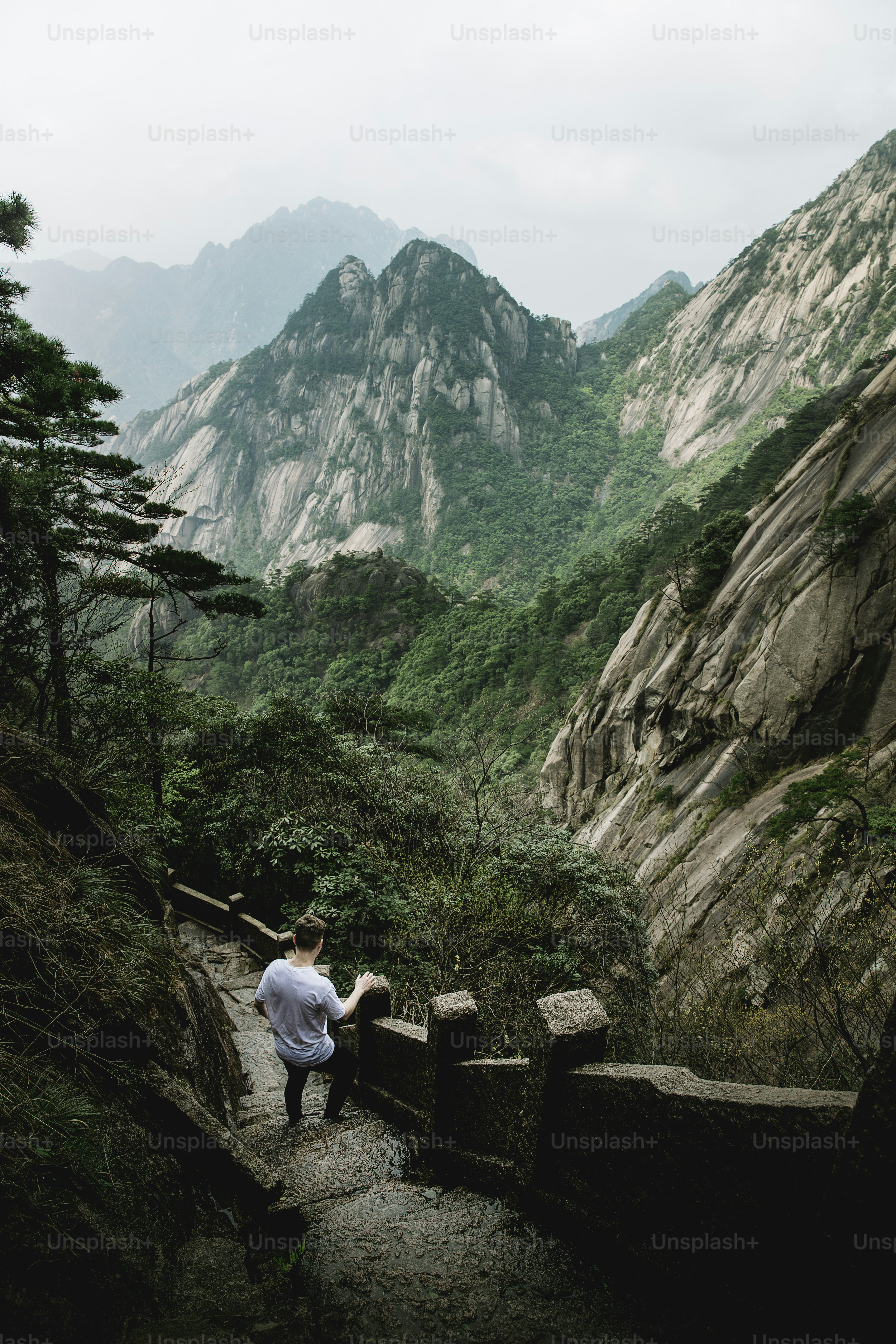 Un homme debout sur un chemin de pierre dans les montagnes