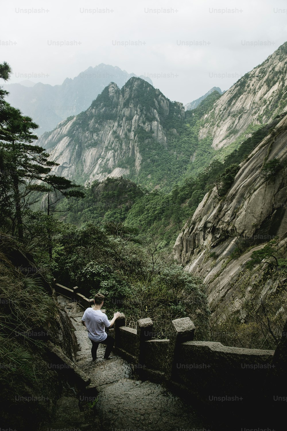 a man standing on a stone path in the mountains