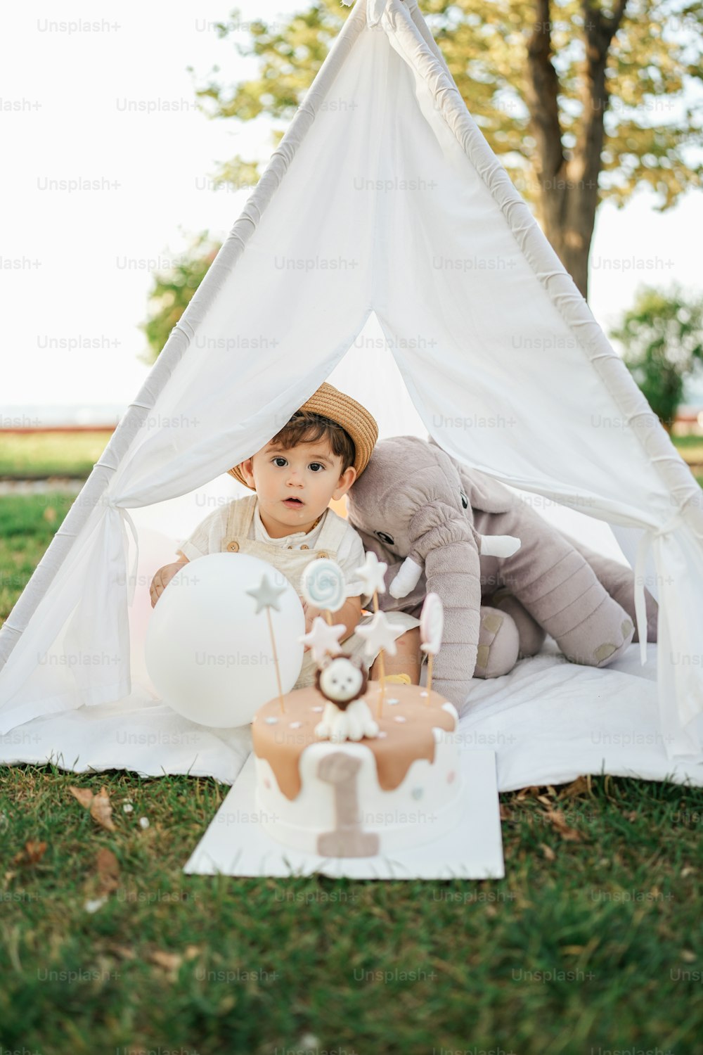 a little boy that is sitting in a teepee