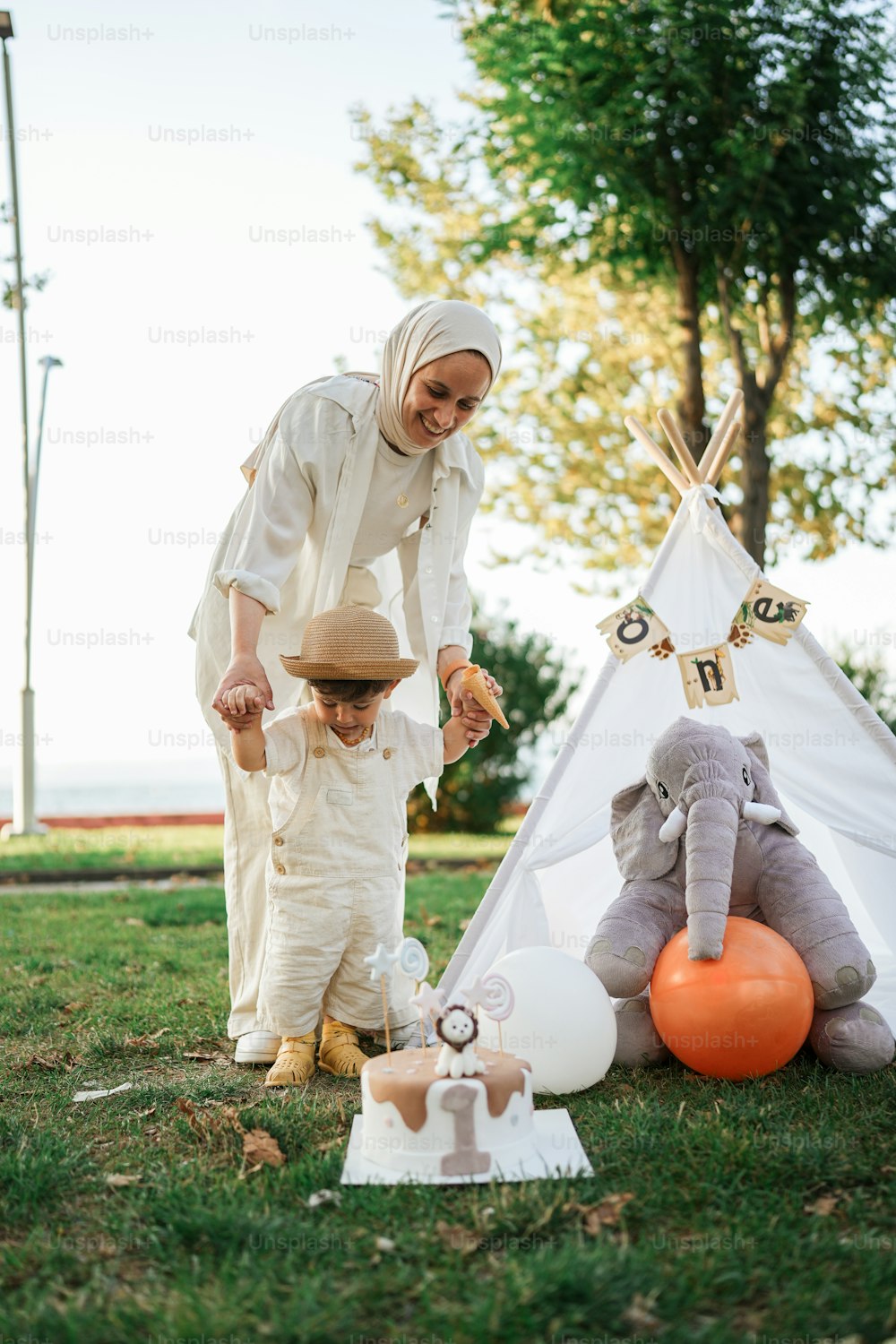 a woman and a child standing in front of a teepee tent