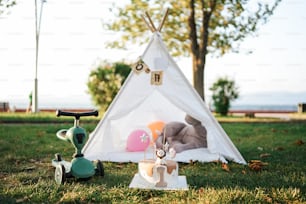 ein Tipi-Zelt mit einem Kuscheltier und einem Spielzeugroller