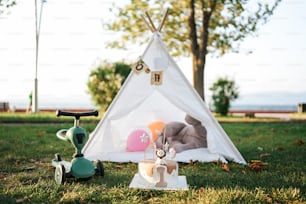 a teepee tent with a stuffed animal and a toy scooter